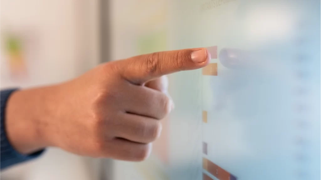 Hand pointing at a digital board, symbolizing data analysis and quality control in the pharmaceutical industry