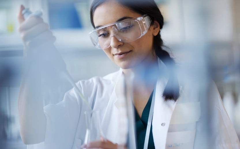 A scientist using a pipette, highlighting standardized processes to avoid costly production errors.